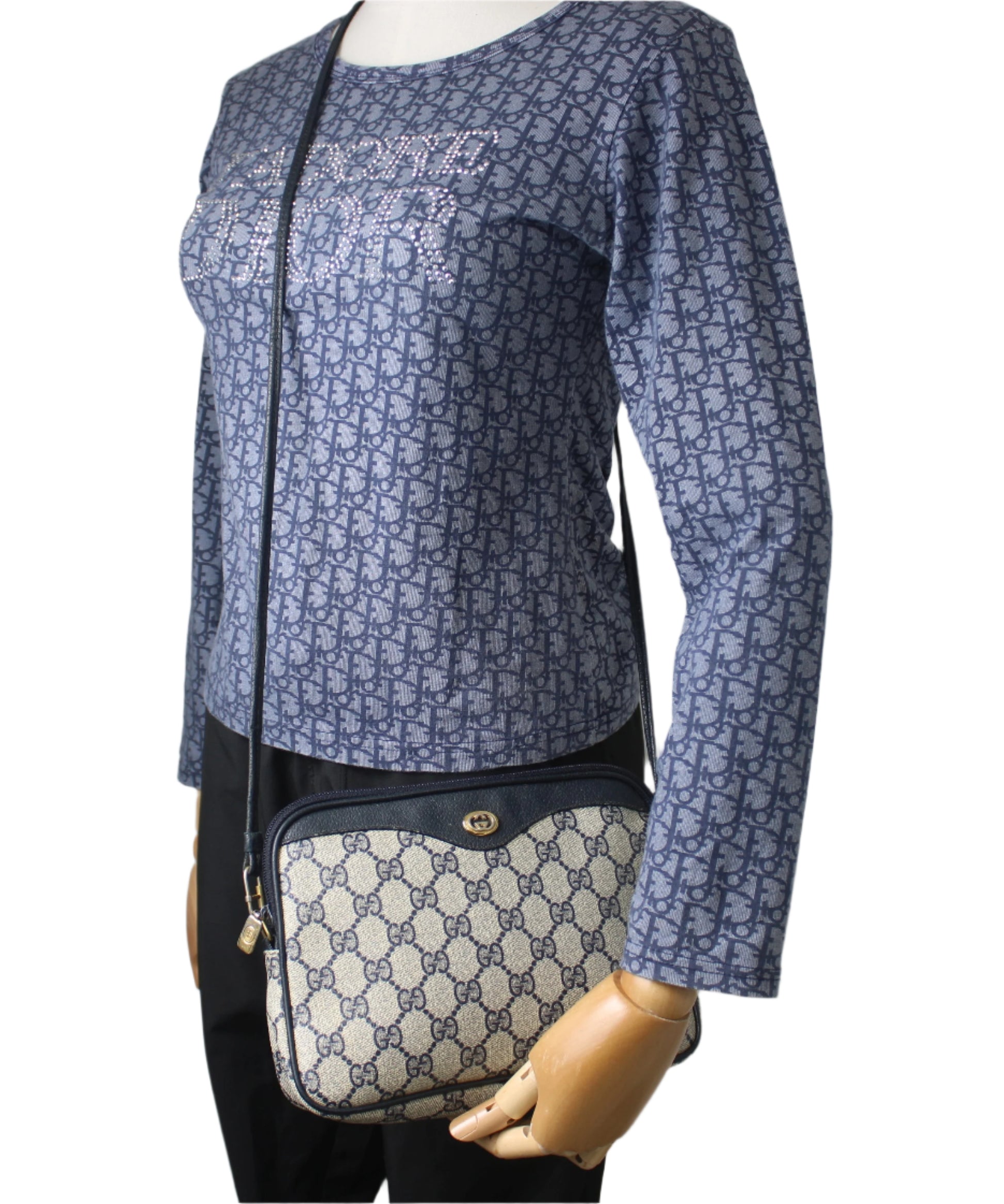 Mannequin wearing a blue patterned outfit with a matching handbag on a gray background