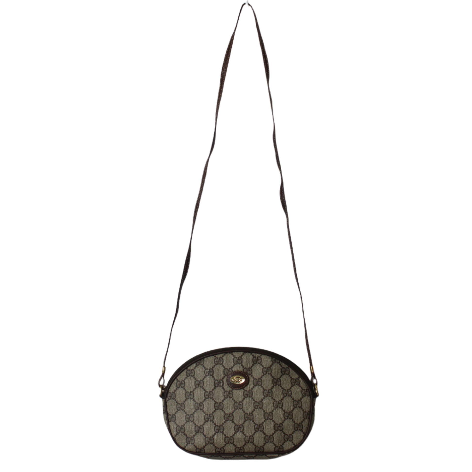 Brown patterned handbag with a strap on a light gray background