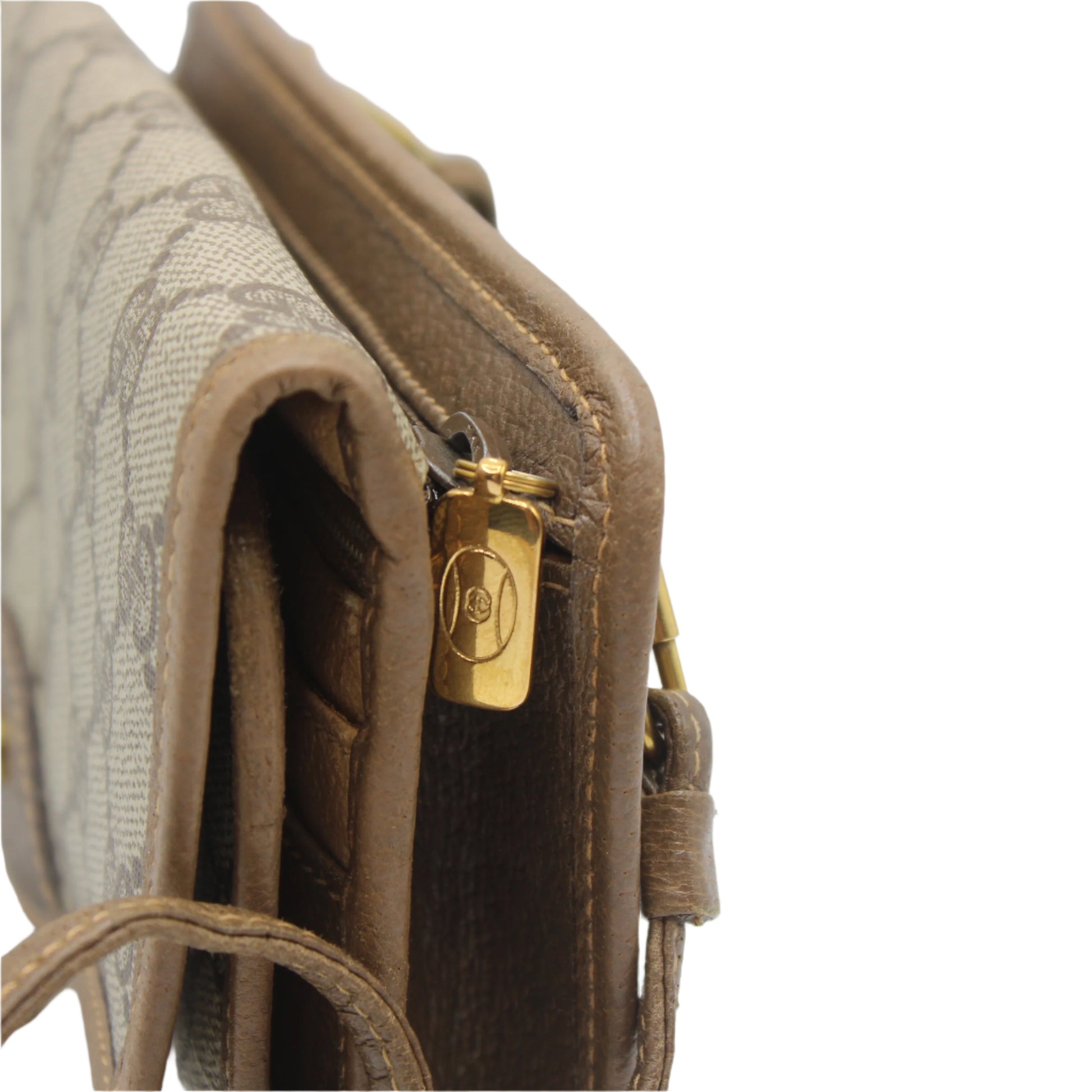 Close-up of a brown textured handbag with a gold tag on a light gray background