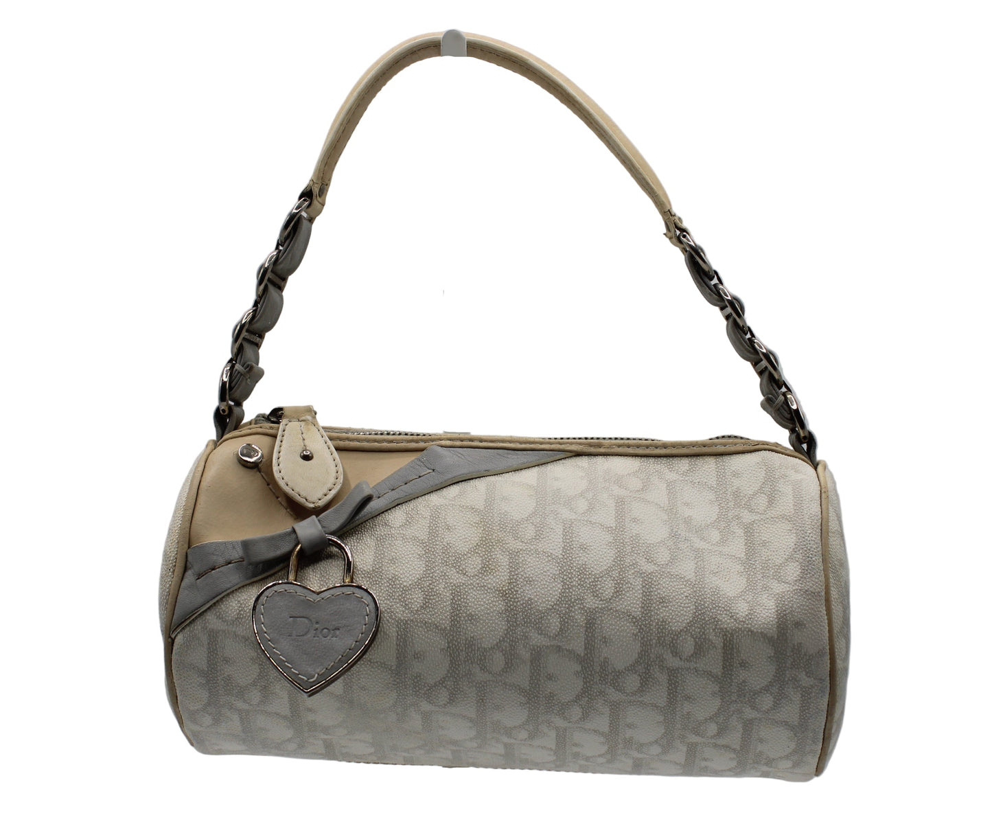 Christian Dior Off White Canvas Romantique Barrel Bag With Leather Trim Beige handbag with a heart-shaped tag on a gray background