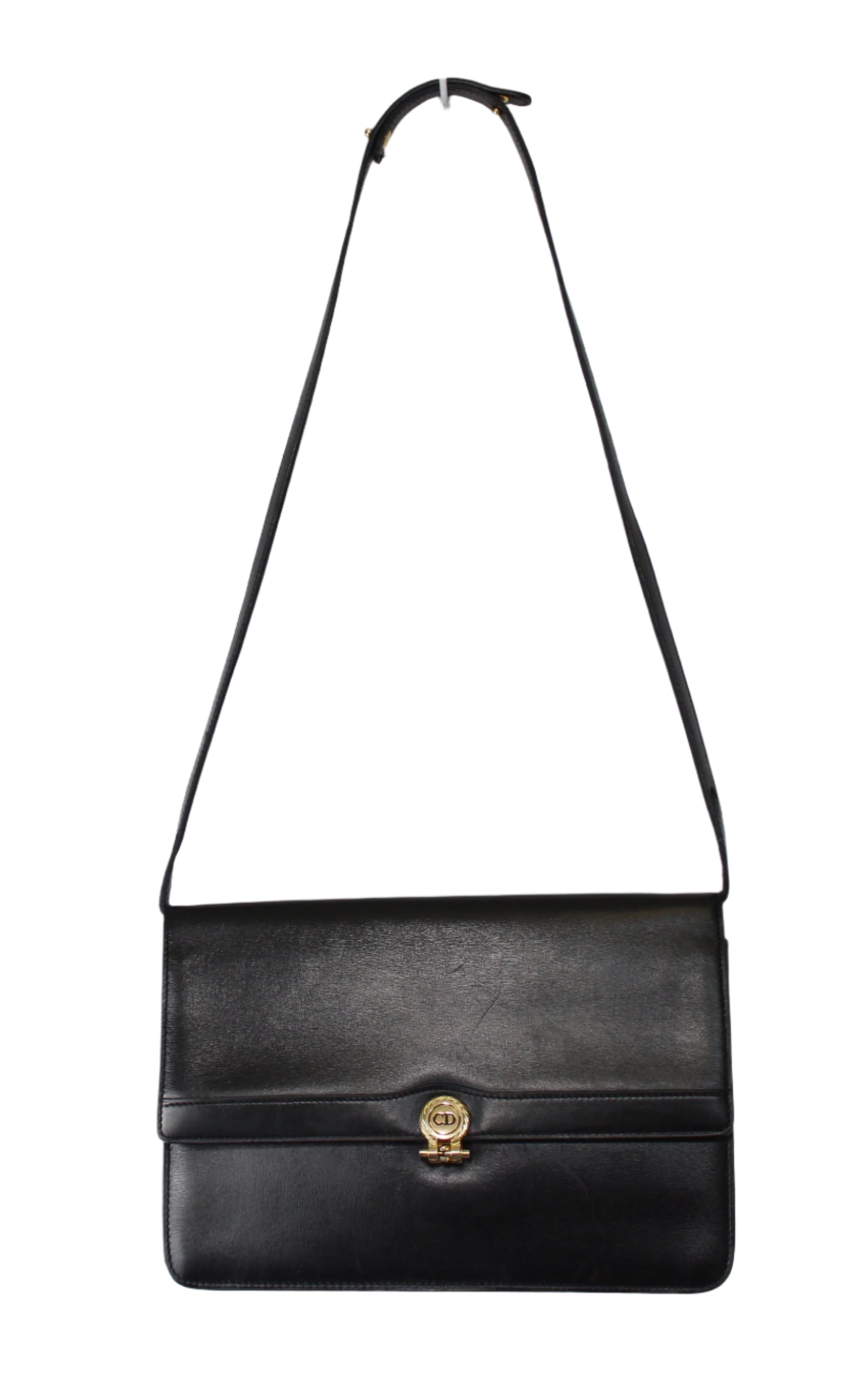 Black shoulder bag with a gold clasp on a light gray background