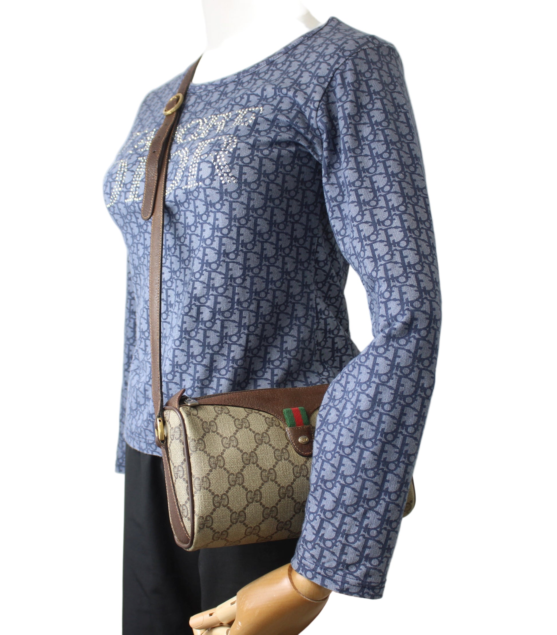 Mannequin wearing a blue patterned shirt with a brown handbag on a white background Gucci Brown GG Supreme Coated Canvas Leather Trim Crossbody Bag