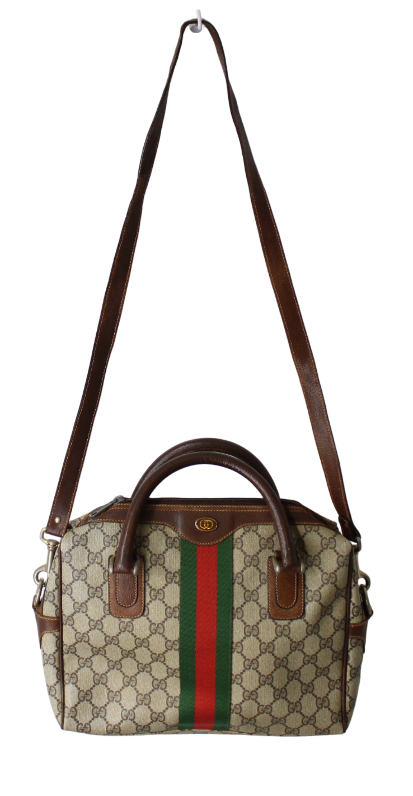 Designer handbag with brown strap and iconic pattern on a white background