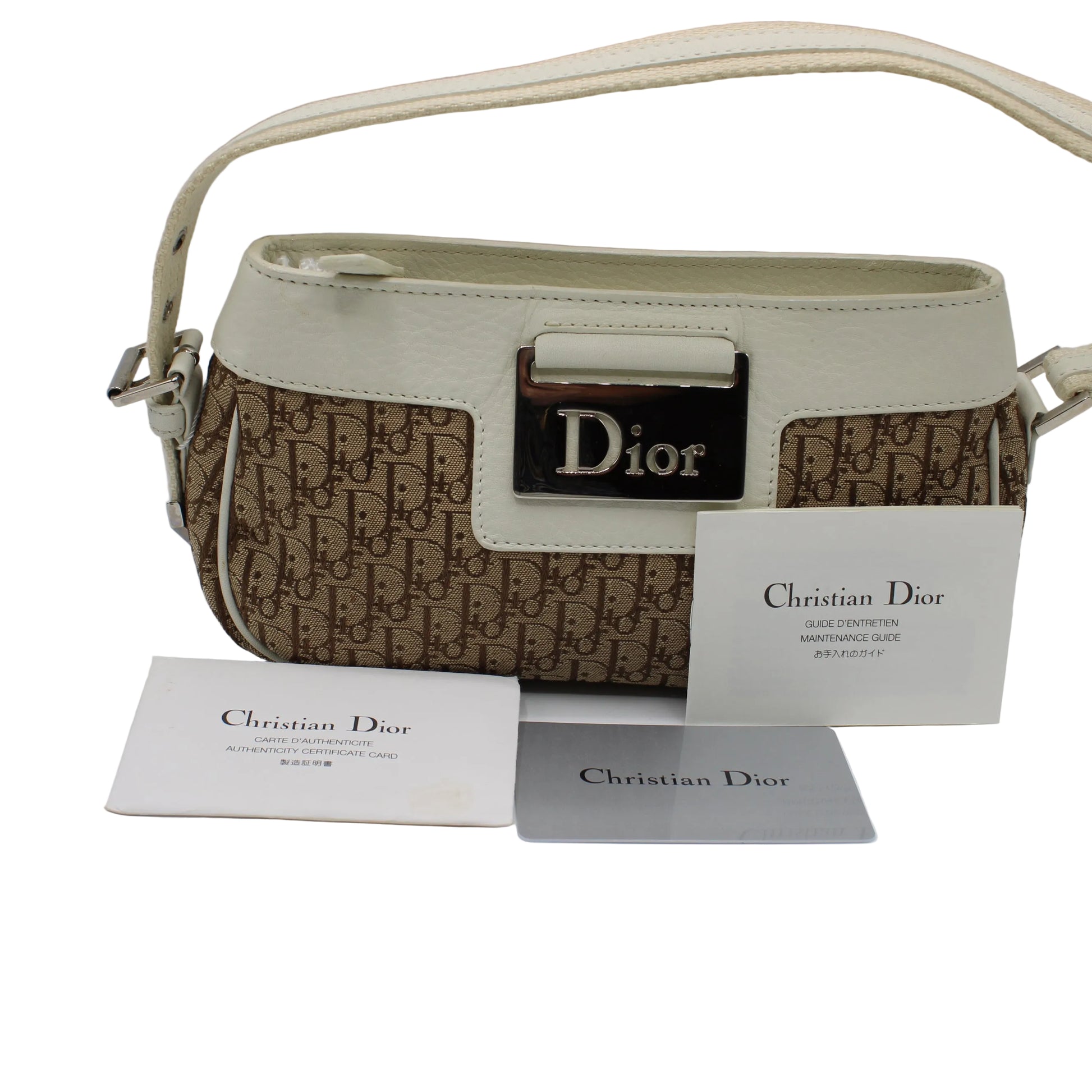 Christian Dior handbag with monogram pattern and brand card on a light gray background