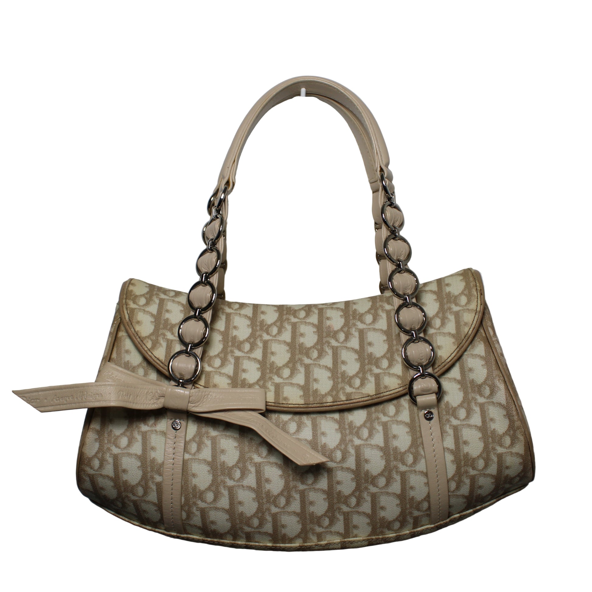 Christian Dior Beige Trotter Canvas Romantique Leather Bow Flap Bag Beige handbag with chain detail on a gray background