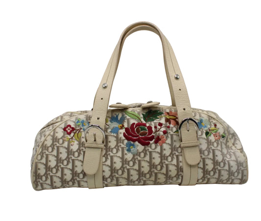 Christian Dior Beige Trotter Embroidered Canvas Bowler Bag A vintage Dior monogram canvas handbag with colorful floral embroidery on the front, featuring beige leather handles and trim, photographed against a neutral light gray background.