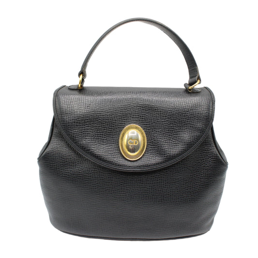 Christian Dior Black Grained Leather 1990s Oval Logo Top Handle Bag Black handbag with a gold clasp on a white background