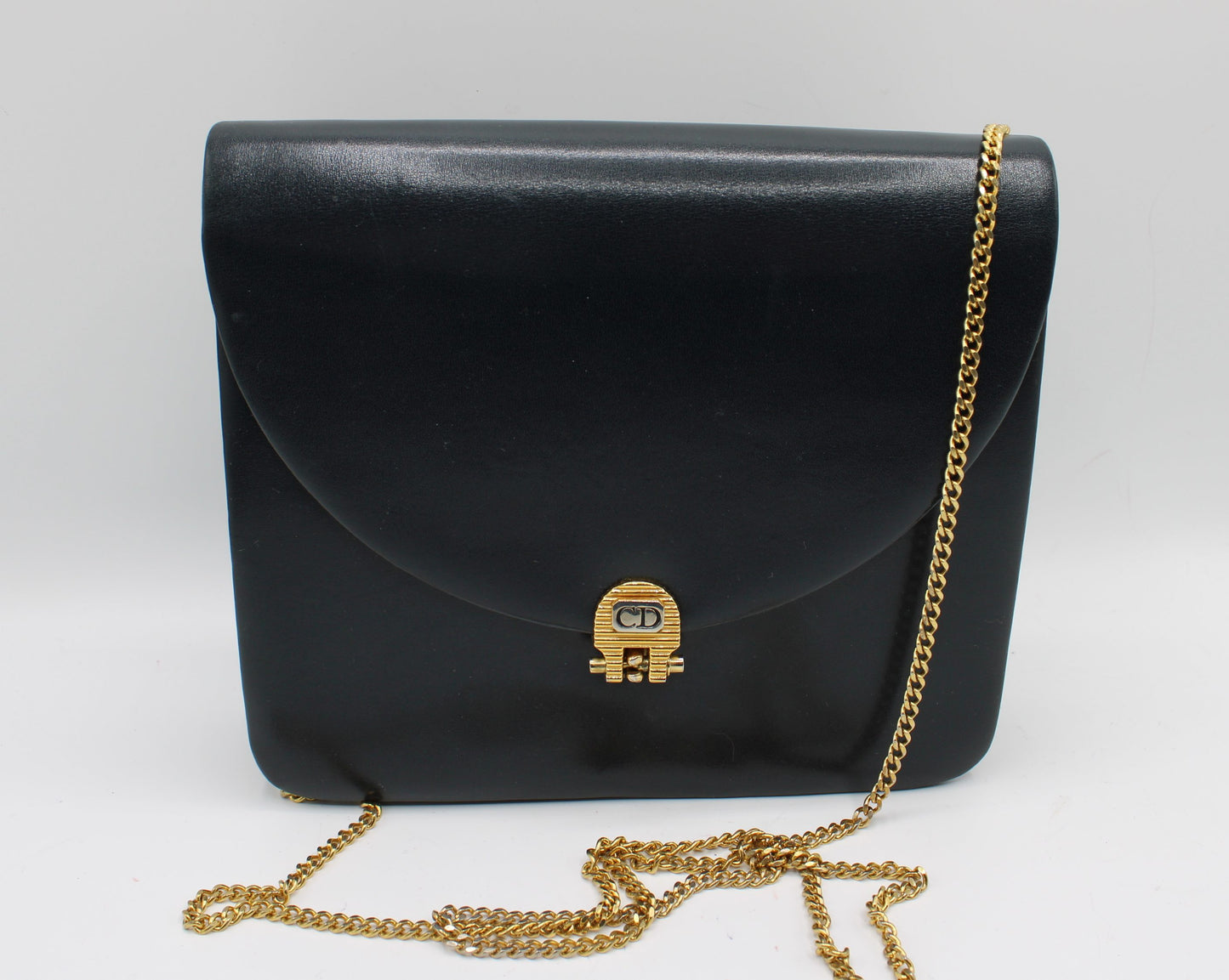 Christian Dior Black Leather Chain Flap Crossbody Bag Black handbag with gold chain strap on a white background