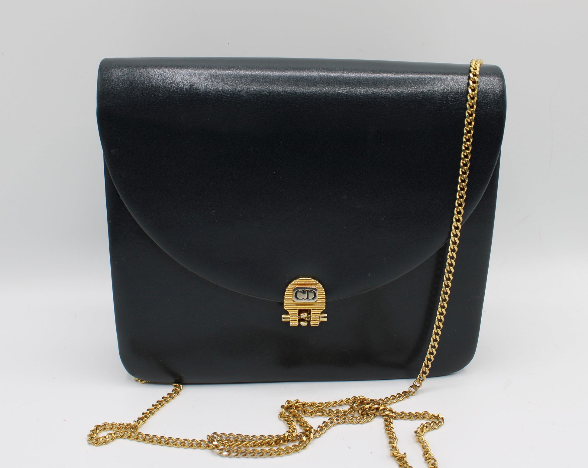 Christian Dior Black Leather Chain Flap Crossbody Bag Black handbag with gold chain strap on a white background