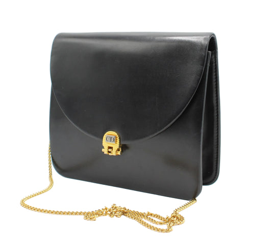 Black handbag with a gold chain and clasp on a white background Christian Dior Black Leather Flap Chain Crossbody Bag left side