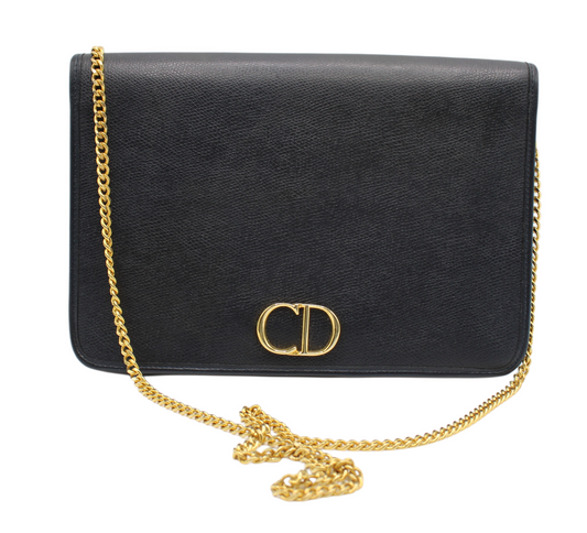 Black handbag with a gold chain and clasp on a white background