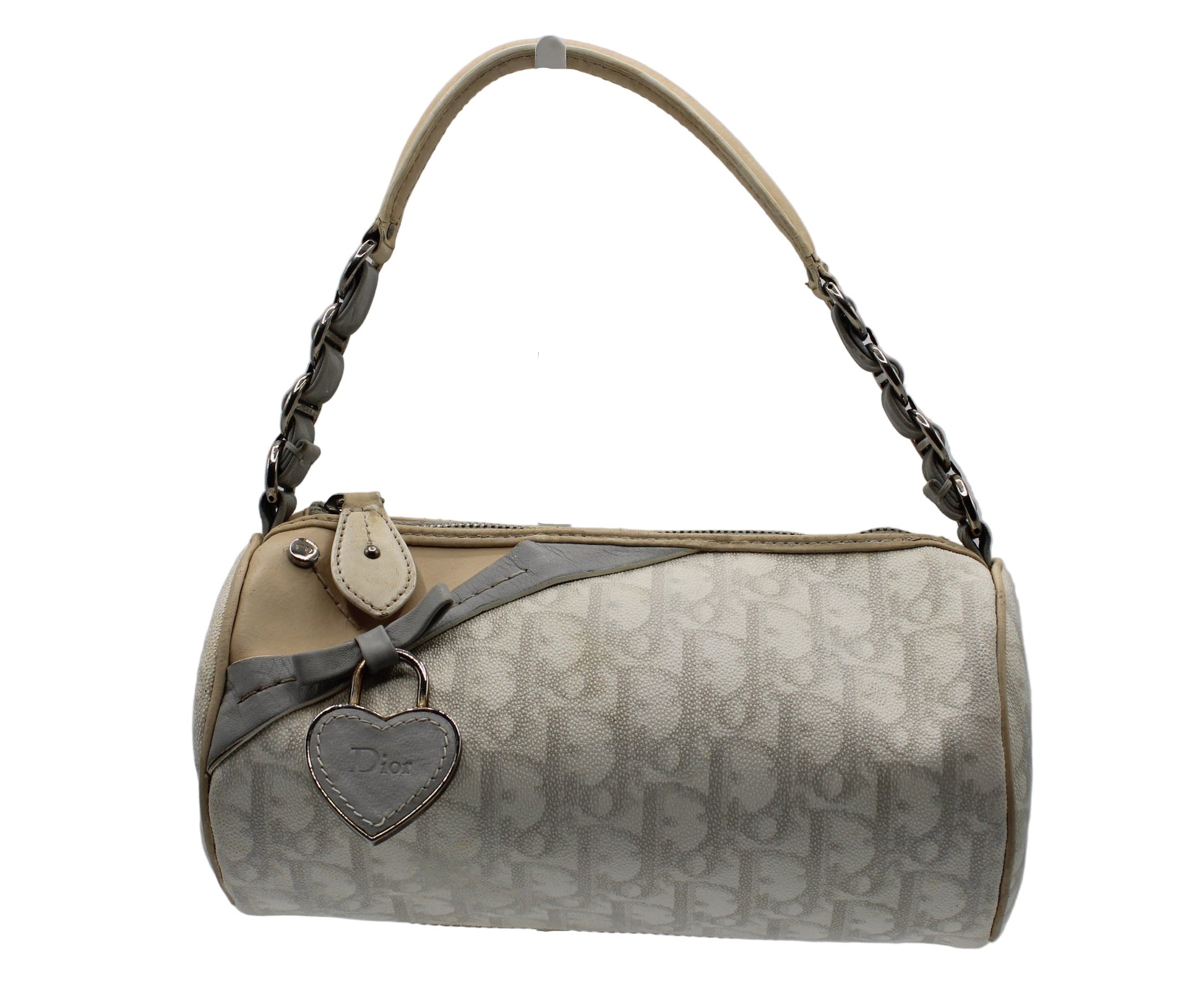 Christian Dior Off White Canvas Romantique Barrel Bag With Leather Trim Beige handbag with a heart-shaped tag on a gray background