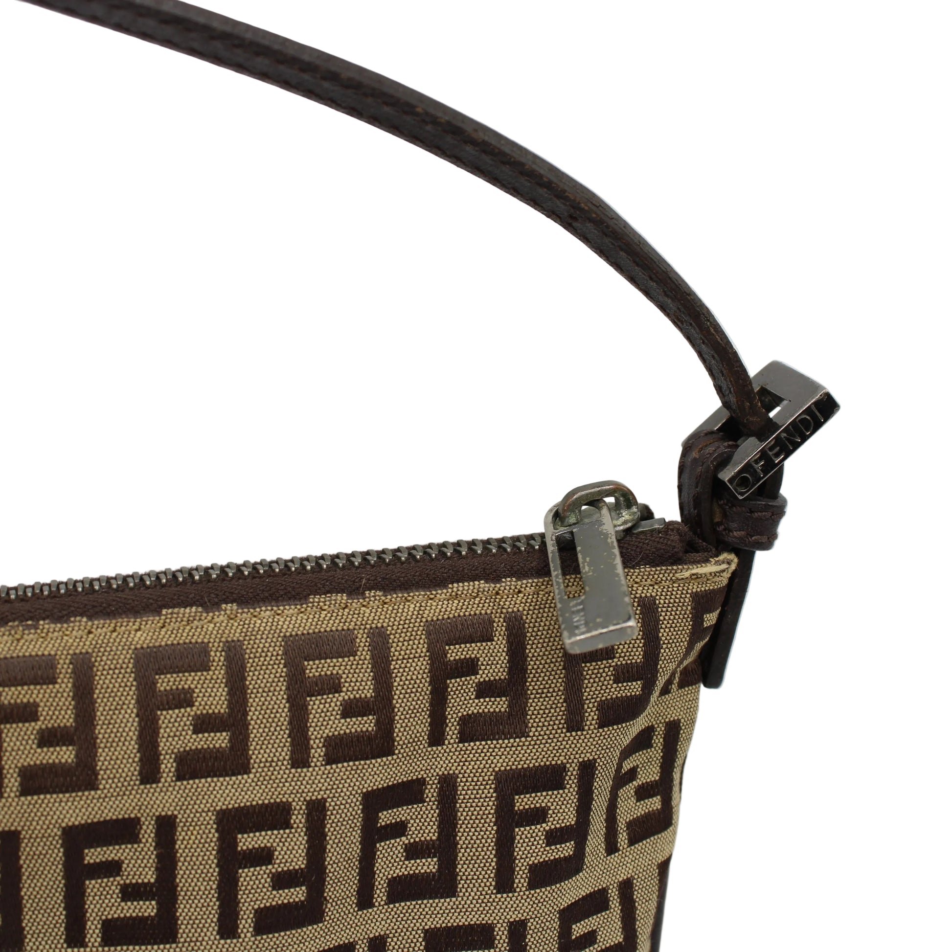 Close-up of a handbag with a prominent brand logo on a light gray background