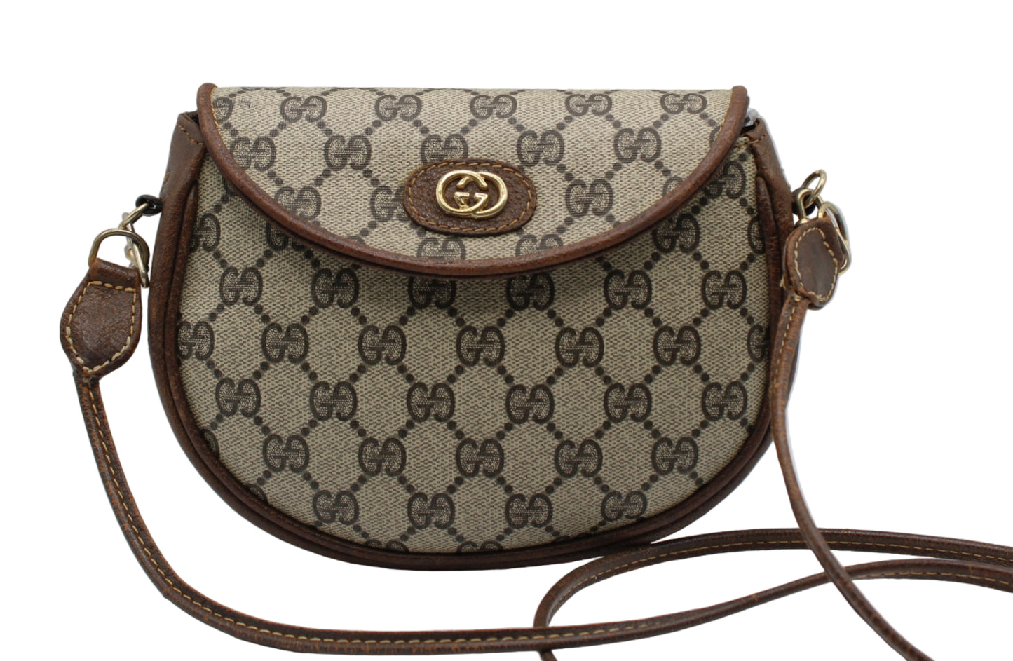 Designer handbag with patterned fabric and brown leather accents on a light gray background